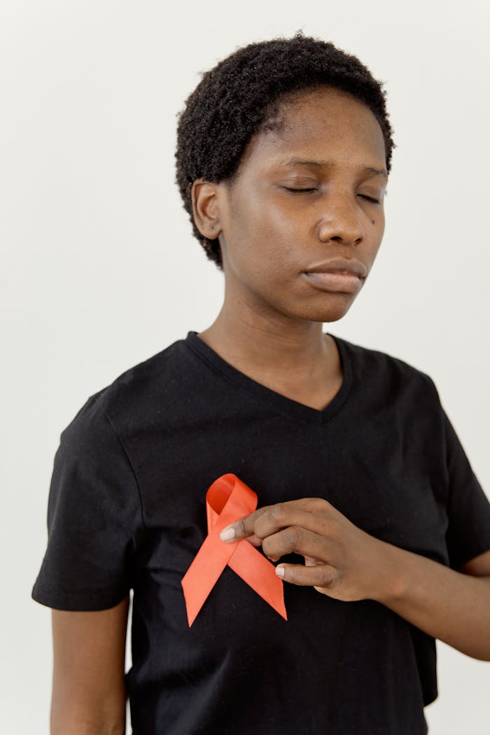 Person with red awareness ribbon on shirt, symbolizing solidarity.